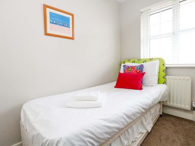 A bedroom with a single bed and wall art at Still Waters in Weymouth