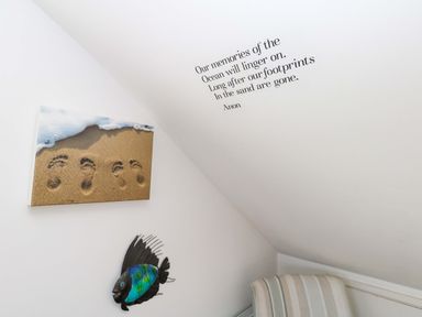 A room with a beach painting and fish decoration at Still Waters in Weymouth
