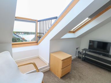 A living room with a window and television at Still Waters in Weymouth