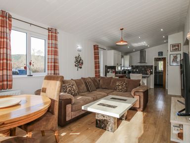 A living room with a sofa and coffee table at Hazel Lodge in Clunton near Clun