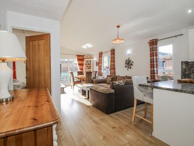 A living room with a sofa and dining table at Hazel Lodge in Clunton near Clun