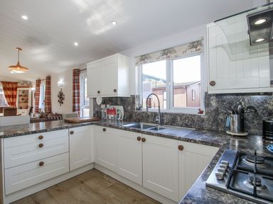 A kitchen with cabinets and a sink at Hazel Lodge Clunton near Clun