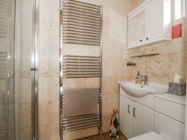 A bathroom with a towel radiator and sink at Hazel Lodge Clunton near Clun