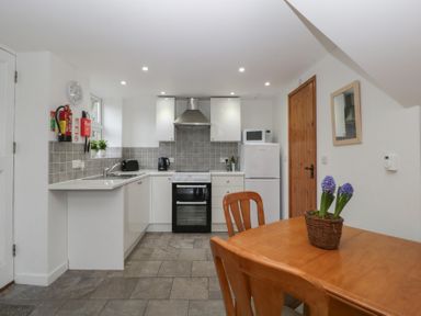 A kitchen with appliances and a dining table at Horse Gin in Lydney