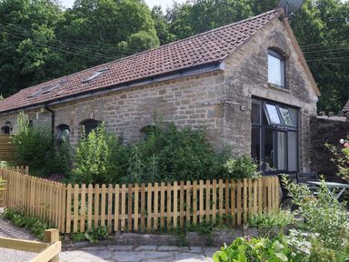 An outdoor view of a stone building with a fence at Horse Gin in Parkend