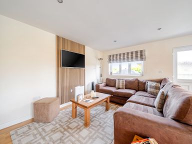 A living room with a sofa and television at James Ville Marina Lodge 7 in Brigg