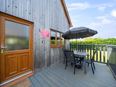 An outdoor area with table and umbrella at James Ville Marina Lodge 7 in Brigg