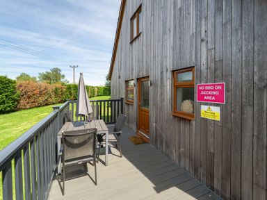 An outdoor decking area with table and chairs at James Ville Marina Lodge 8 in Brigg