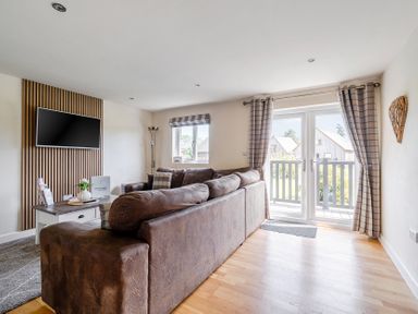 A living room with a sofa and television at James Ville Marina Lodge 8 in Brigg