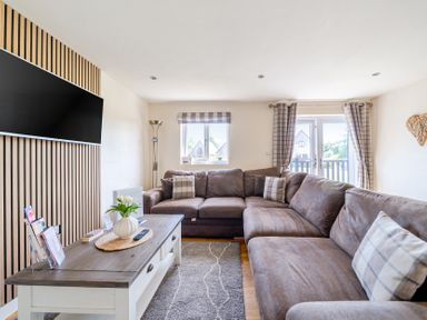 A living room with a sectional sofa and television at James Ville Marina Lodge 8 in Brigg