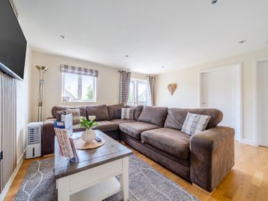 A living room with a sofa and television at James Ville Marina Lodge 8 in Brigg