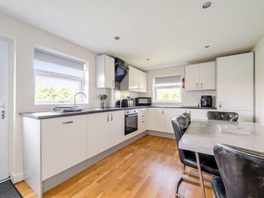 A kitchen with appliances and a dining table at James Ville Marina Lodge 8 in Brigg