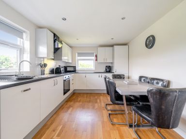 A kitchen with cabinets, appliances, and dining table at James Ville Marina Lodge 8, Brigg