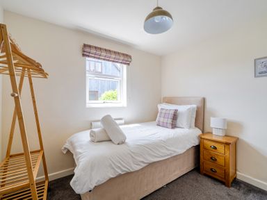 A bedroom with a single bed and clothes rack at James Ville Marina Lodge 8 in Brigg