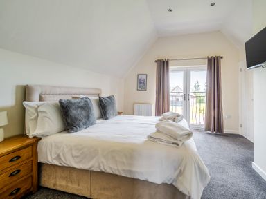 A bedroom with a bed and balcony doors at James Ville Marina Lodge 8, Brigg