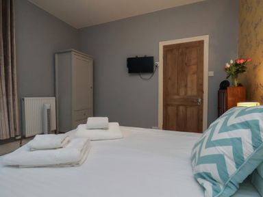 A bedroom with a bed and television at South Villa Sandsend near Whitby