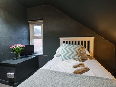 A bedroom with a bed and television at South Villa Sandsend near Whitby