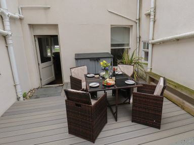 An outdoor dining area with a table and chairs at South Villa in Sandsend near Whitby