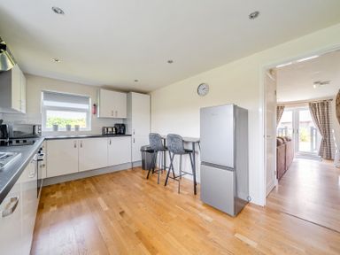 A kitchen with a fridge and stools at James Ville Marina Lodge 9 in Brigg