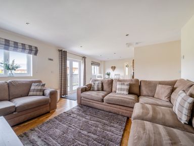 A living room with a sofa and a table at James Ville Marina Lodge 13 in Brigg