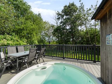 An outdoor area with a hot tub and seating at James Ville Marina Lodge 13 in Brigg