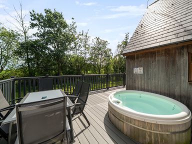 A deck with a hot tub and outdoor furniture at James Ville Marina Lodge 13 in Brigg