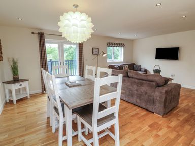 A dining area with a table and chairs at James Ville Marina Lodge 14, Brigg