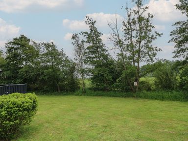 A garden with grass and trees at James Ville Marina Lodge 14 in Brigg