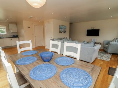 A dining room with a wooden table and blue placemats at James Ville Marina Lodge 21 in Brigg