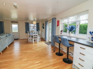 A dining room with a table and bar stools at James Ville Marina Lodge 21 in Brigg