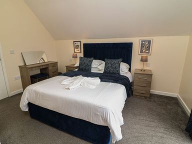 A bedroom with a bed and desk at James Ville Marina Lodge 21 in Brigg