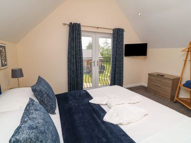 A bedroom with a bed and television at James Ville Marina Lodge 21 in Brigg