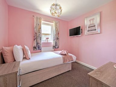 A bedroom with a single bed and television at James Ville Marina Lodge 23 in Brigg