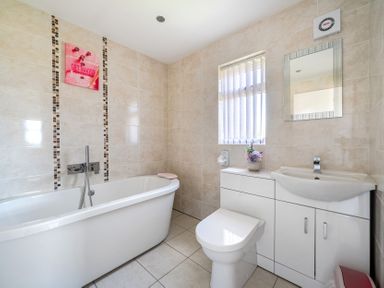 A bathroom with a bathtub, toilet, sink, and window at James Ville Marina Lodge 23 in Brigg