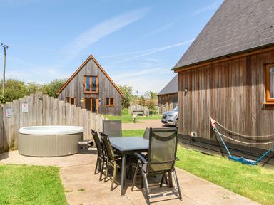 An outdoor area with a table, chairs, hot tub, and houses at James Ville Marina Lodge 23, Brigg