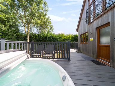 An outdoor area with a hot tub and chairs at James Ville Marina Lodge 10 in Brigg