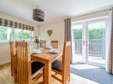 A dining room with a wooden table and chairs at James Ville Marina Lodge 10 in Brigg