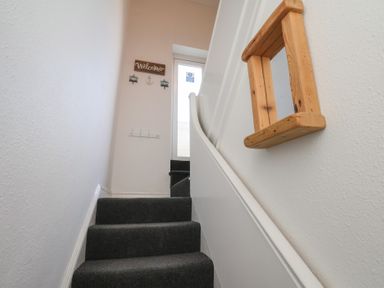 A staircase with a door and a welcome sign at Apartment 3 in Scarborough