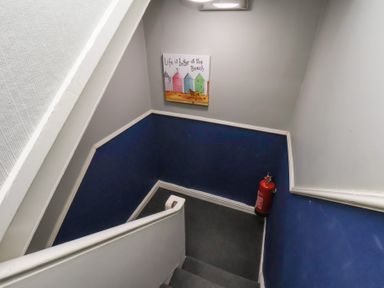 A staircase with wall artwork and a fire extinguisher at Apartment 3 in Scarborough
