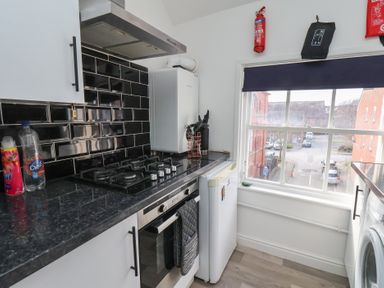 A kitchen with stove, fridge and window at Apartment 3 Scarborough