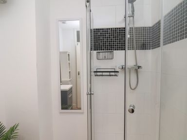 A bathroom with a shower, mirror, and sink at Apartment 3 in Scarborough