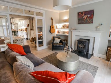 A living room with a sofa and fireplace at The Secret Garden in Narberth