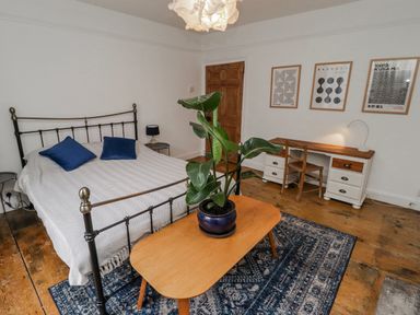 A bedroom with a bed and desk at The Secret Garden in Narberth