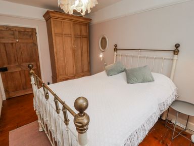 A bedroom with a bed and wardrobe at The Secret Garden in Narberth