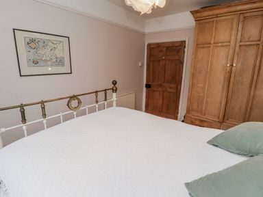 A bedroom with a bed and wardrobe at The Secret Garden in Narberth