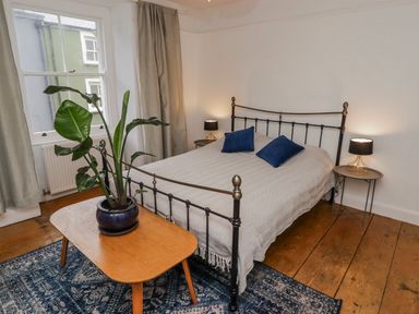 A bedroom with a bed and side table at The Secret Garden in Narberth