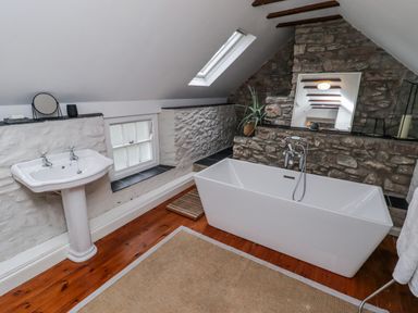 A bathroom with a bathtub and sink at The Secret Garden in Narberth