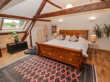 A bedroom with a wooden bed and a plant at The Secret Garden in Narberth