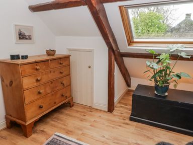 A bedroom with a dresser and a small door at The Secret Garden in Narberth