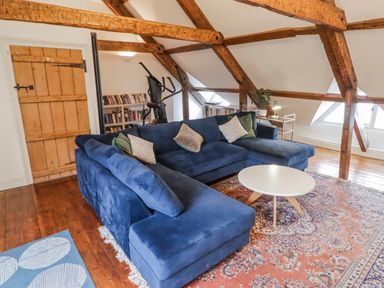 A living room with a blue sofa and coffee table at The Secret Garden in Narberth